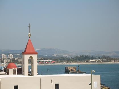 כנסיית סנט ג'והן  על רקע המפרץ והרי הגליל התחתון